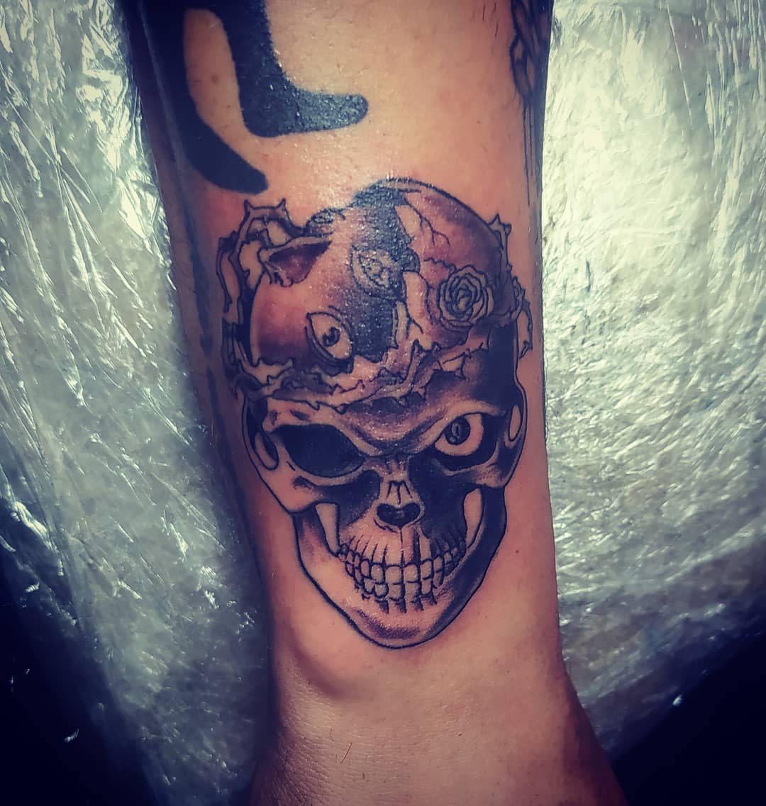 Tattoo of the Skull Knight from Berserk on the forearm, featuring his iconic skeletal face with a crown of thorns and a menacing expression